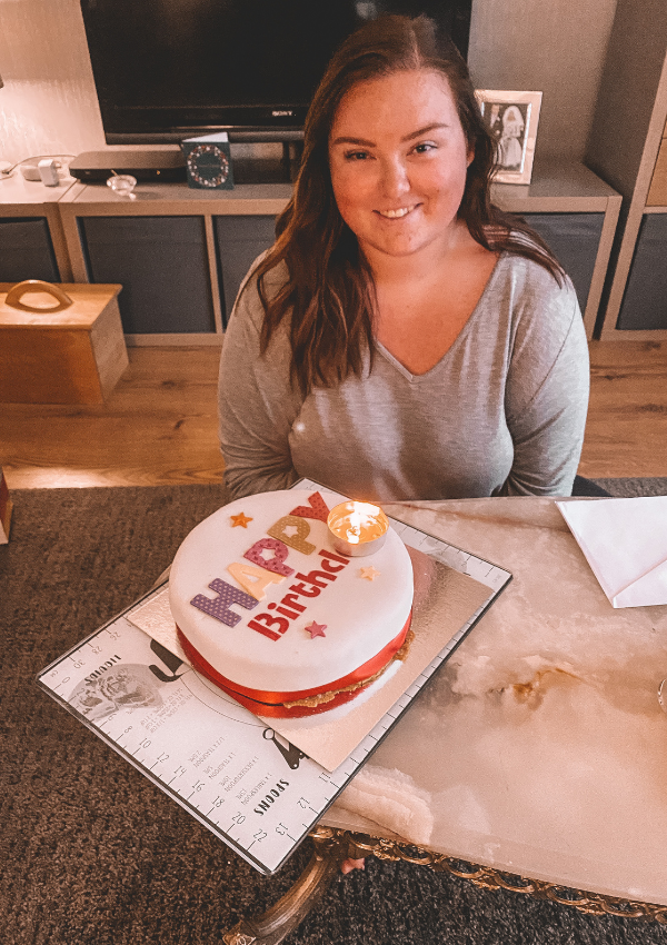 photo of me sat down on the floor infront of a coffe table with a birthday cake infront of me on the table